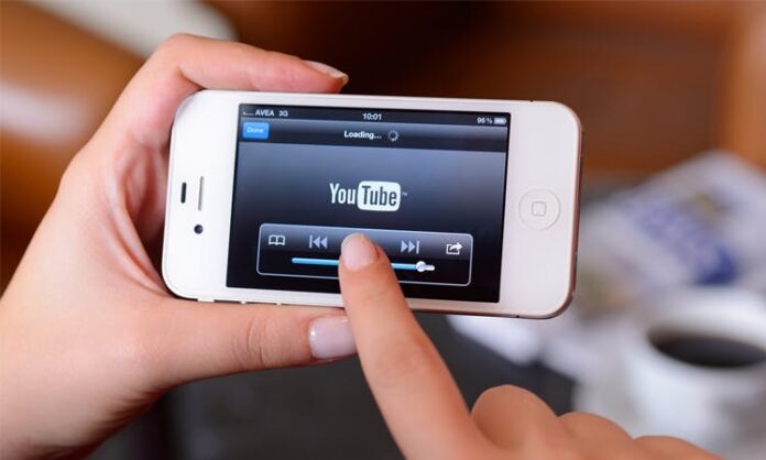 finger pointing at Youtube on mobile phone