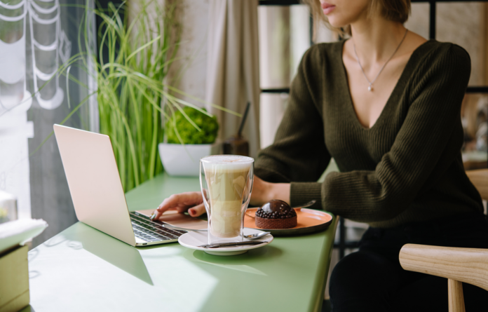 Small business owner using her laptop drinking a latte in a cafe.png