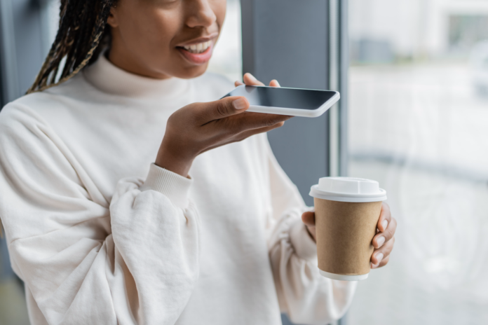 Young woman making money recording her voice with smartphone.png